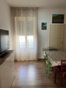 a living room with a table and a television and a dining table and a window at Gallipoli Dragonfly Inn - Appartamento in Gallipoli
