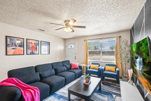 a living room with a blue couch and a tv at Cozy 4BD - Fire Pit & BBQ - 10 Min from Downtown in Lubbock