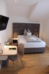 1 dormitorio con 1 cama grande, escritorio y silla en Schwanenhof Hotel und Restaurant, en Erkelenz