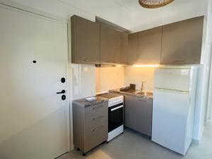 a kitchen with white appliances and a white refrigerator at Golden Beach Seafront Apartment in Nea Moudania