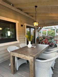 a wooden table and chairs on a patio at Domki Lawendowe in Sasino
