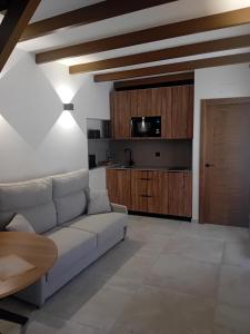 a living room with a white couch and a kitchen at La Posada de Doña Carmen in Villanueva de Alcardete