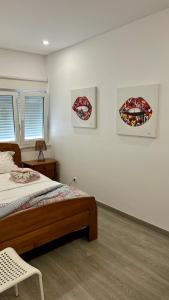 a bedroom with a bed and two pictures on the wall at Casa Berlenga in Peniche