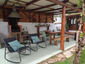a patio with a table and chairs and a stove at Casinha do pinhal in Colares