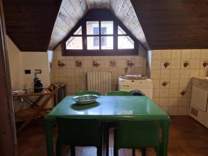 a kitchen with a green table and green chairs at La casa di Arnika in Baveno +42 photos