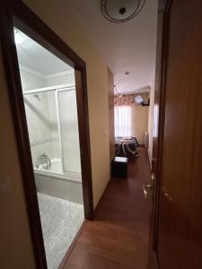 a room with a bathroom with a shower and a door at Pensión Arcano in Arzúa
