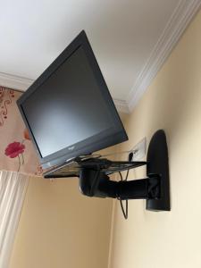 a flat screen tv on a wall with a microphone at Pensión Arcano in Arzúa