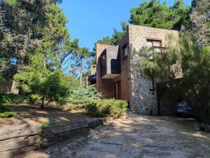 a stone house with a car parked in front of it at PiedrasBlancas in Mar de las Pampas