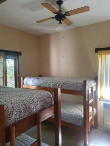 a bedroom with two beds and a ceiling fan at PiedrasBlancas in Mar de las Pampas