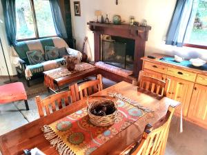 a living room with a table and a fireplace at PiedrasBlancas in Mar de las Pampas
