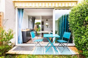 a blue table and chairs on a patio at Studio en bord de mer in Damgan