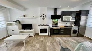 eine Küche mit schwarzen und weißen Geräten in einem Zimmer in der Unterkunft Escapada de Relax y Diseño con Piscina y Barbacoa in Torremolinos