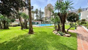 einen Park mit Palmen und einem Pool in der Unterkunft Escapada de Relax y Diseño con Piscina y Barbacoa in Torremolinos