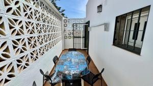 einen Tisch und Stühle auf dem Balkon eines Hauses in der Unterkunft Escapada de Relax y Diseño con Piscina y Barbacoa in Torremolinos