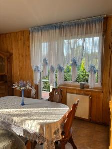 a dining room with a table and a window at Agroturystyka Natalia in Bukówka