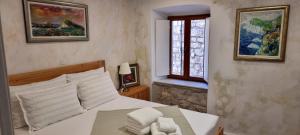 a bedroom with a white bed and a window at Lorenzo Old Town in Dubrovnik