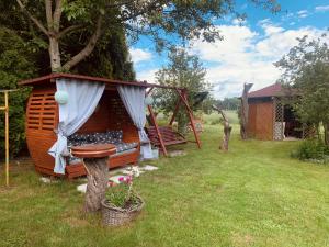 a small tree house with a bench in a yard at Agroturystyka Natalia in Bukówka +20 photos