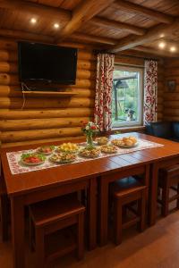 a large wooden table with plates of food on it at Likimo ratas in Paliepis