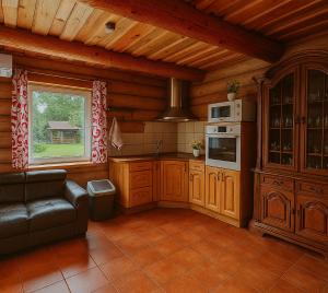 a kitchen with wooden cabinets and a couch in a room at Likimo ratas in Paliepis +66 photos