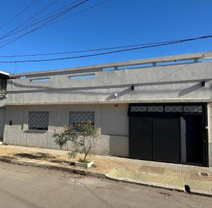 a gray building with a large garage on a street at Casa LH en Villa María, Córdoba in Villa María