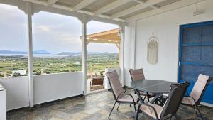 a dining room with a table and chairs on a balcony at Bayview Villa with Jaccuzi - Milos in Zefiría +46 photos