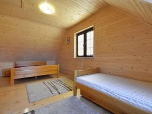 Cabaña de madera con 2 camas y ventana en Domki w stylu góralskim Myśliwska 20, en Grzybowo