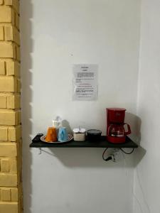 a shelf with a coffee maker and cups on it at Suites Prime in Marataizes