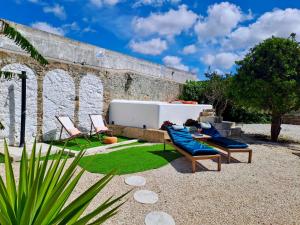 a patio with two chairs and a tub in front of a building at Pool oasis with private parking -Vigia 8 in Torres Vedras