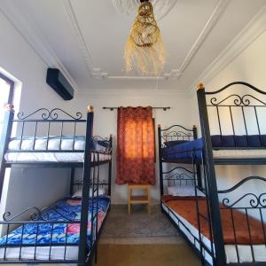 a room with four bunk beds and a ceiling at WARZAZAT Hostel in Ouarzazate