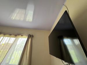 a flat screen tv in a room with a window at Casa De Daniel in Daniel Flores