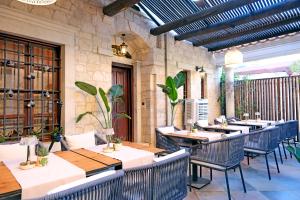 a restaurant with tables and chairs in a building at Mai Alaçatı in Çeşme