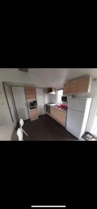 a small kitchen with white cabinets and a window at Mobilhome in Litteau