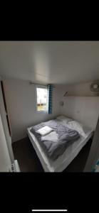 a small bedroom with a bed with a window at Mobilhome in Litteau +14 photos