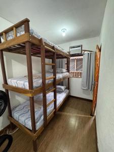 a room with three bunk beds in a house at Suítes como uma onda in Abraão