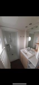 a bathroom with a sink and a mirror at Mobilhome in Litteau