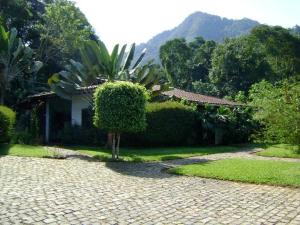 a house with a palm tree in front of a driveway at Casa de 730m2 no Exclusivo Condomínio Portogalo com Piscina Privada e Cais para iates de até 55 Pés in Angra dos Reis +15 photos