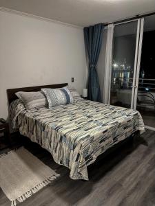 a bedroom with a bed and a large window at Departamento esmeralda Iquique x dia in Iquique