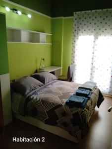 a green bedroom with a bed and a window at Apartamento ROMA in Nájera