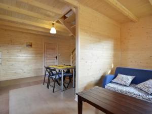 Una sala de estar con un sofá azul y una mesa. en Domki w stylu góralskim Myśliwska 20, en Grzybowo