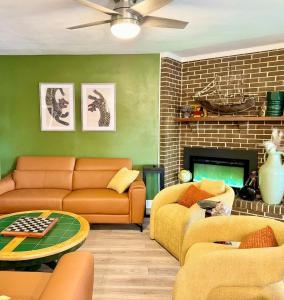 a living room with orange furniture and a fireplace at Happy Palette Home Close to downtown Fenced yard in Sanford