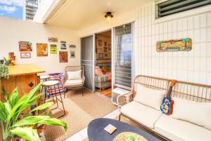 a living room with a couch and a table at Surf & Sip Ocean View Tiki Style in Honolulu
