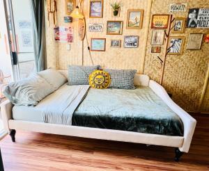a bed in a room with pictures on the wall at Surf & Sip Ocean View Tiki Style in Honolulu