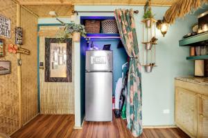 a refrigerator in a kitchen next to a door at Surf & Sip Ocean View Tiki Style in Honolulu