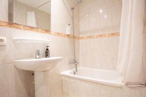 a white bathroom with a sink and a bath tub at Hotel Playa Sol in El Arenal +32 photos