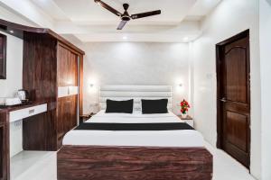 a bedroom with a large bed and a ceiling fan at Super Hotel O SGPGI in Lucknow