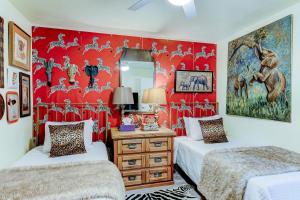 a bedroom with two beds and a red wall at Happy Palette Home Close to downtown Fenced yard in Sanford