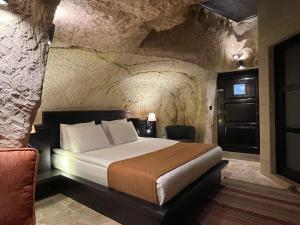 a bedroom with a bed in a stone room at Casa Cappadocia in Ortahisar