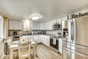 a kitchen with white cabinets and a table and a refrigerator at Truman Lake Retreat Large Deck and On-Site Fishing! in Clinton