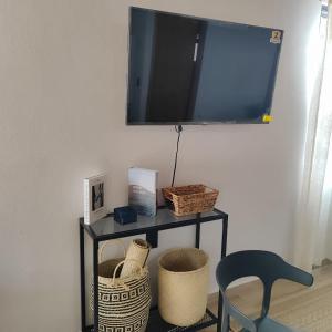 Un estante con cestas y un televisor en una pared. en Hotel Cabañas de los Angeles, en Tequila