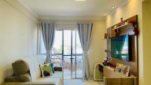 a living room with a couch and a large window at Apto Lindo e Amplo, 150m Praia in Cabedelo